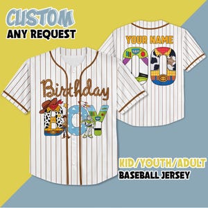 May include: White baseball jersey with brown stripes. The front of the jersey has a design of the characters from Toy Story, Woody and Buzz Lightyear, spelling out "Birthday Boy". The back of the jersey has the text "Your Name" and a number 00.