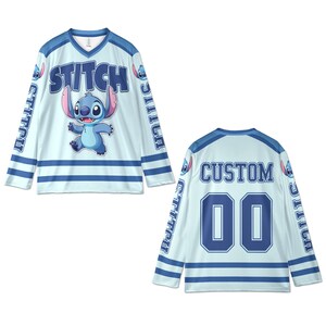 Puede incluir: Jersey de hockey azul claro con el personaje Stitch de Lilo & Stitch. La parte delantera muestra "STITCH" y una imagen de Stitch. Las mangas tienen "STITCH" impreso. La parte trasera tiene "CUSTOM" y el n&uacute;mero "00".