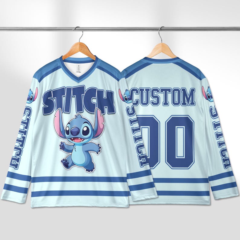 Puede incluir: Jersey de hockey azul claro y blanco con el personaje Stitch. La parte delantera de la camiseta tiene la palabra "STITCH" y una imagen de Stitch. La parte trasera de la camiseta tiene la palabra "CUSTOM" y el n&uacute;mero "00".