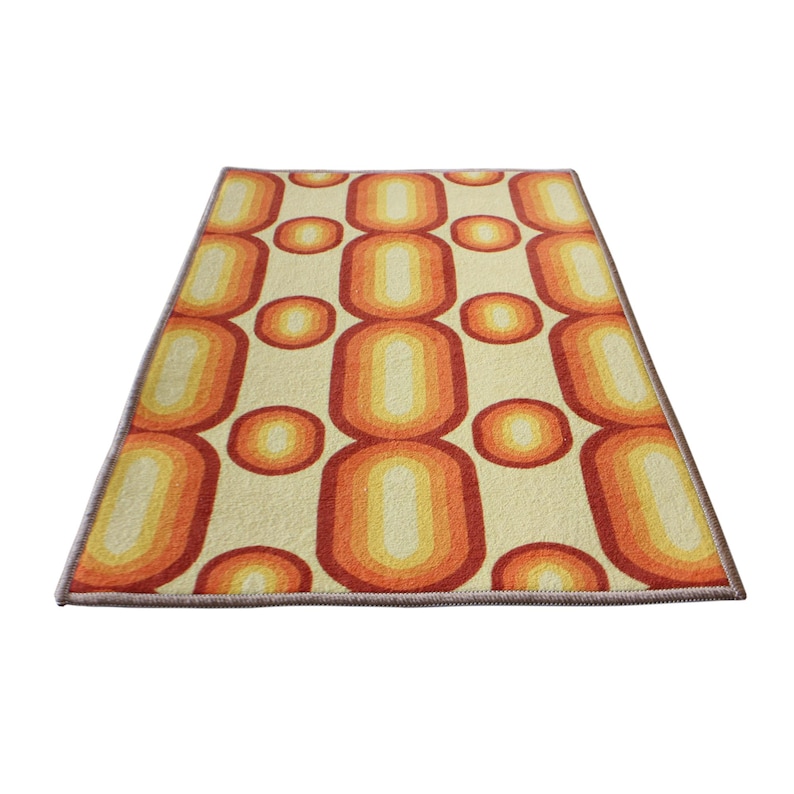 May include: A vintage style rug with a geometric pattern of orange, yellow, and cream circles and ovals on a cream background. The rug has a brown border.