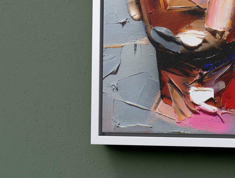 May include: Abstract painting of a face with bold strokes of red, pink, white, and blue paint. The painting is framed in a white frame.