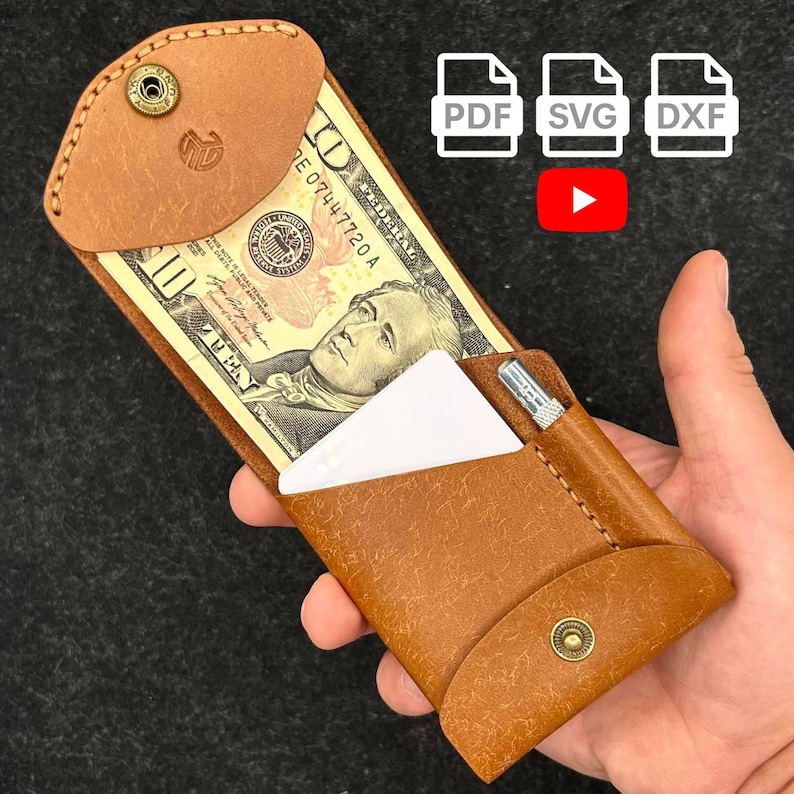 Op de afbeelding: Een bruine leren portemonnee met een biljet van tien dollar en een witte kaart. De portemonnee heeft een drukknoopsluiting en een kleine metalen pen. De afbeelding bevat ook pictogrammen voor PDF-, SVG- en DXF-bestanden, plus een YouTube-afspeelknop.