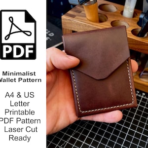 May include: A dark brown leather wallet with a triangular flap closure and light-coloured stitching along the edges. The text on the left reads: PDF Minimalist Wallet Pattern A4 & US Letter Printable PDF Pattern Laser Cut Ready.