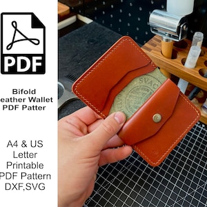 May include: A tan leather bifold wallet featuring a front flap with a metal snap closure, visible stitching along the edges, and multiple card slots. The text on the left side reads PDF Bifold Leather Wallet PDF Pattern A4 & US Letter Printable.