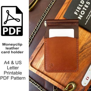 May include: A brown leather money clip card holder with a white card partially visible. The holder has a minimalist design and is displayed on a wooden surface. Text on the left side reads "Moneyclip leather card holder" and "A4 & US Letter Printable PDF Pattern."