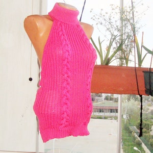 K&ouml;nnte beinhalten: Ein pinkfarbenes gestricktes Halstuch mit hohem Kragen und Zopfmuster.