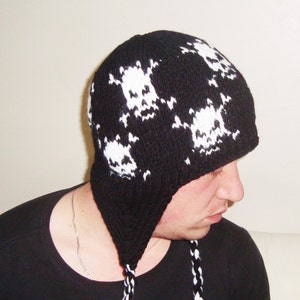 May include: Black knit beanie with a white skull pattern. The beanie has a long, dangling tail.