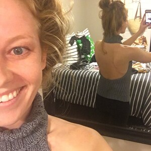 K&ouml;nnte beinhalten: Nahaufnahme einer Frau, die einen grauen Strickpullover mit Rollkragen tr&auml;gt. Der Pullover hat einen hohen Kragen und eine lockere Passform. Die Frau l&auml;chelt und schaut in die Kamera.