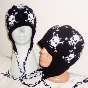 May include: Two black and white knit skull hats with long ties. One hat is a beanie style and the other is a slouchy hat with a flap that covers the ears.