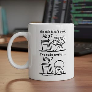 Può includere: Tazza in ceramica bianca con un design umoristico. La tazza presenta un'illustrazione a fumetti in bianco e nero e il testo "the code doesn't work, Why?" e "the code works... Why?" sul davanti. La tazza ha un manico curvo.