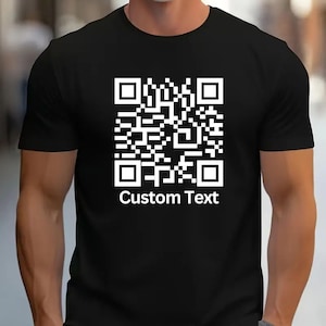 Puede incluir: Camiseta negra con un código QR blanco y el texto "Custom Text" impreso en la parte delantera.