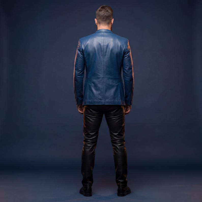 K&ouml;nnte beinhalten: Ein blauer Lederblazer und eine schwarze Lederhose. Der Blazer hat ein klassisches Design mit einem fallenden Revers und einem Zwei-Knopf-Verschluss. Die Hose ist eng anliegend und hat einen schlanken, modernen Look. Das Outfit ist vor einem dunkelblauen Hintergrund.