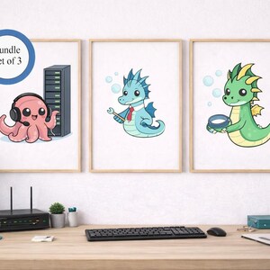 Peut inclure: Ensemble de 3 impressions d'art encadrées. Chaque impression présente un personnage de dessin animé : une pieuvre rose avec un casque, un dragon bleu avec une clé et un dragon vert avec un bol. Les impressions sont affichées sur un bureau.