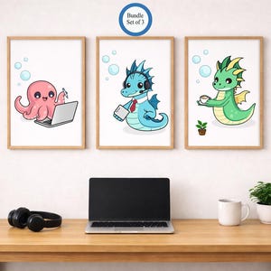 May include: Three framed art prints featuring cartoon characters: a pink octopus with a laptop, a blue dragon with a headset, and a green dragon with a cup. The prints are above a desk with a laptop, headphones, a mug, and a plant.