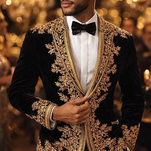 May include: A black velvet blazer with intricate gold embroidery. The jacket features a classic lapel, a white dress shirt, and a black bow tie. The gold embroidery is detailed with floral patterns.