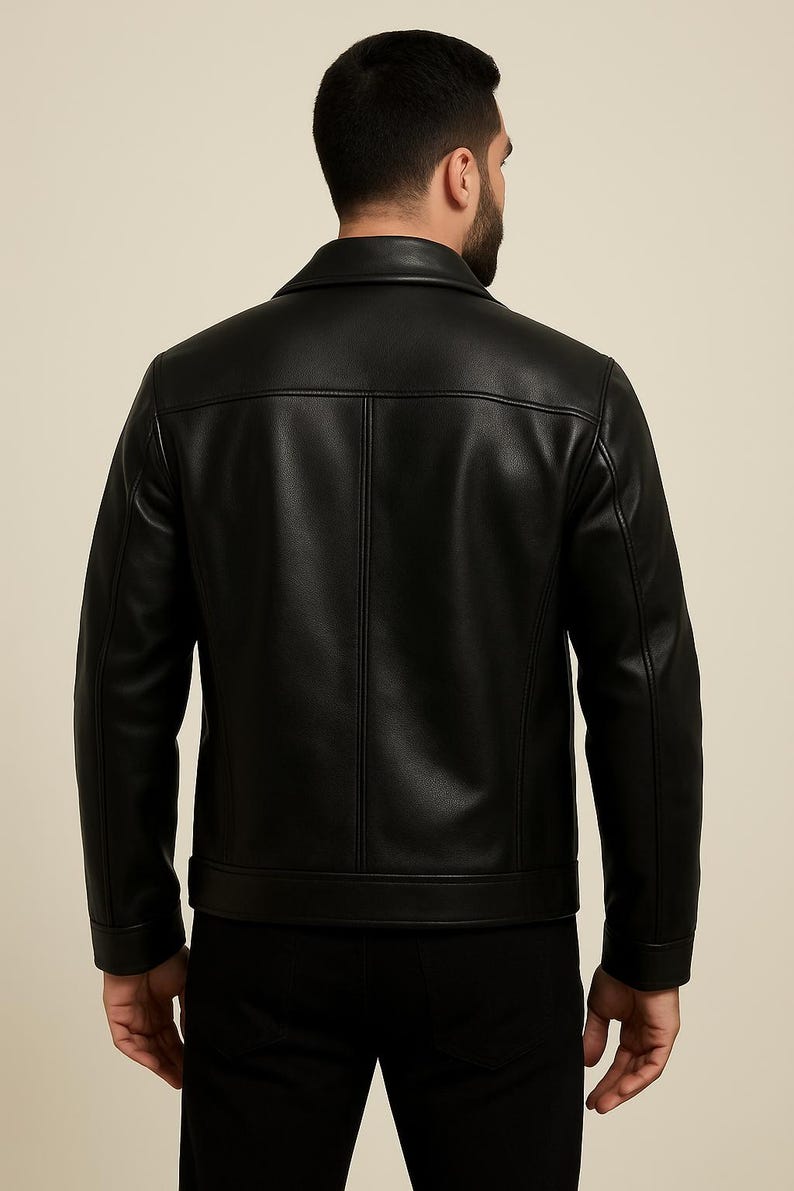 May include: Black leather jacket with a classic collar and a tailored fit. The jacket features a button closure and a clean, minimalist design. The back view showcases the jacket's structured silhouette and stitching details. A timeless outerwear piece.