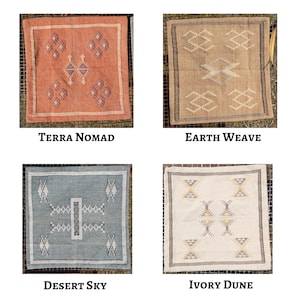 May include: Four square decorative pillows with geometric designs. The pillows are in shades of terra cotta, tan, light blue, and ivory. Each pillow has a different pattern and is labeled with a name: Terra Nomad, Earth Weave, Desert Sky, and Ivory Dune.