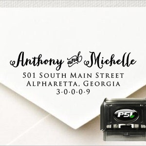 Op de afbeelding: Een witte envelop met een zwart retouradreslabel waarop staat "Anthony and Michelle, 501 South Main Street, Alpharetta, Georgia 3.0.0.0.9". In de rechterbenedenhoek van de afbeelding staat een zwart-groene zelfinktende stempel.