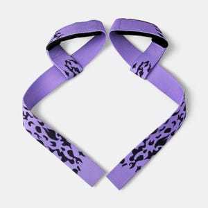 Two purple powerlifting straps with anime flame design and padded loops. Fitness accessory for wrist support during weightlifting and gym workouts.