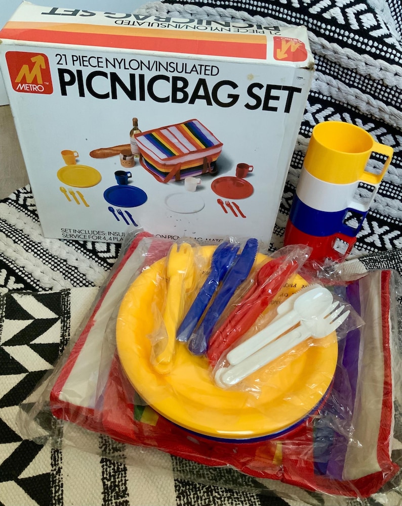 May include: A 21-piece picnic set with a nylon insulated bag, plates, cups, forks, knives, and spoons. The set is packaged in a box with a red, white, and blue color scheme.