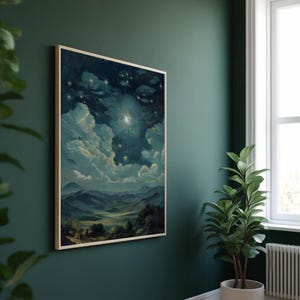 Puede incluir: Una pintura de paisaje enmarcada representa una escena celestial con una brillante explosi&oacute;n de estrellas, nubes y monta&ntilde;as. La obra de arte, en tonos de azul, verde y blanco, se exhibe en una pared verde oscuro. Una planta en maceta se encuentra cerca, agregando un toque de naturaleza a la habitaci&oacute;n.