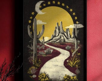 May include: A framed desert landscape art print. The artwork features a yellow sun, a crescent moon, and stars in a dark sky. A winding path leads to a mountain range, with cacti and desert plants in the foreground.