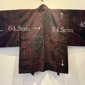 May include: Black kimono with a red grid pattern. The kimono measures 74.5 cm across the back, 64.5 cm for the sleeve length, and 45 cm for the sleeve width. The garment is hanging on a hanger.