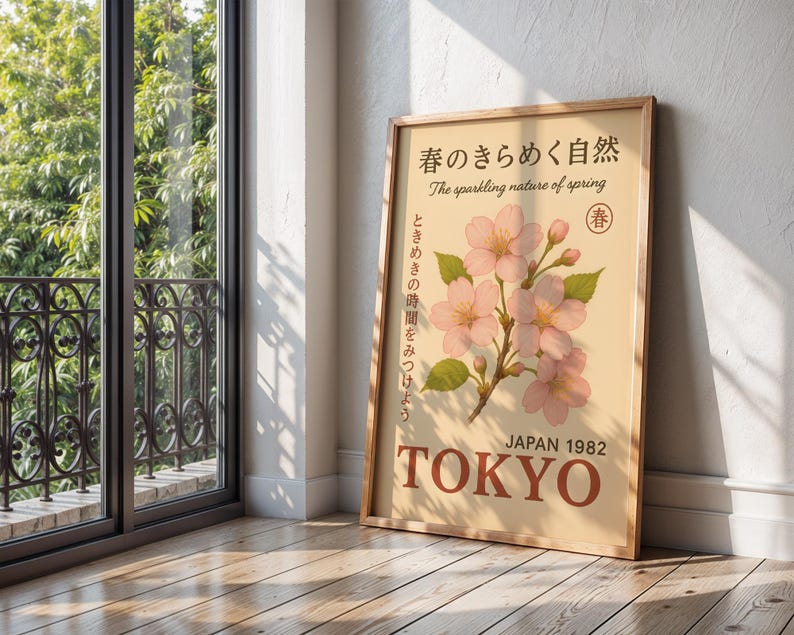 K&ouml;nnte beinhalten: Ein gerahmtes Poster mit hellbraunem Hintergrund zeigt rosa Kirschbl&uuml;ten und den Text "The sparkling nature of spring". Das Poster enth&auml;lt den Text "JAPAN 1982 TOKYO".