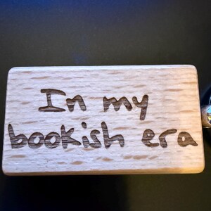 May include: A wooden keychain with the text "In my bookish era" engraved on it.