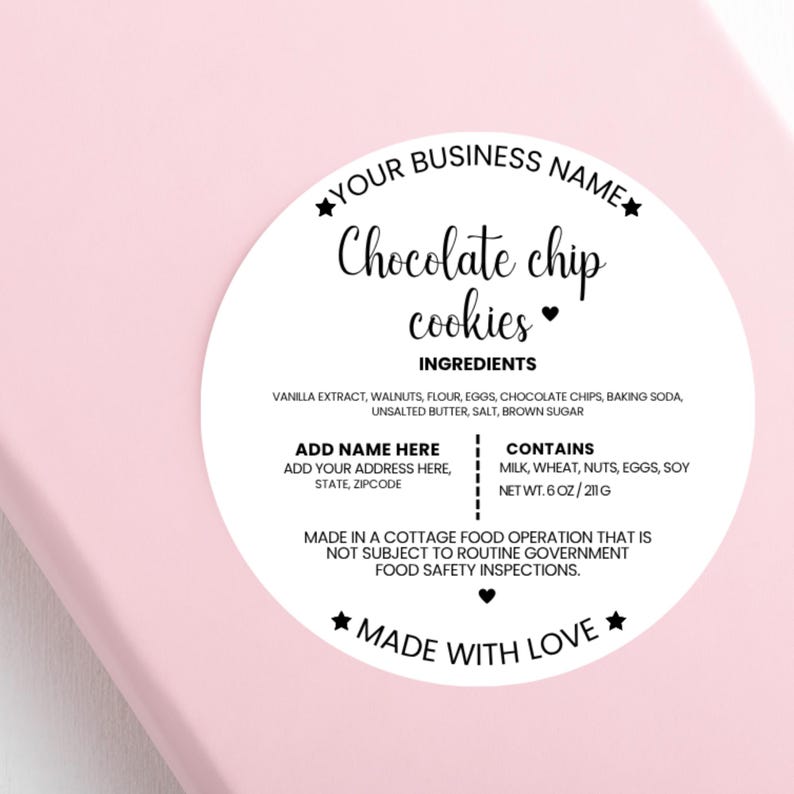 May include: A round sticker on a pink surface. The sticker reads "Your Business Name" and "Chocolate chip cookies" in a handwritten font. Ingredients and allergen information are listed. The sticker says "Made with Love".