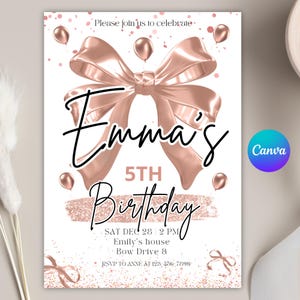 Puede incluir: Una tarjeta de invitación de cumpleaños blanca con detalles en oro rosa. Presenta un gran lazo, globos y el texto "Emma's 5th Birthday". La tarjeta también incluye la fecha, hora, lugar y detalles de RSVP. El logotipo de Canva es visible.