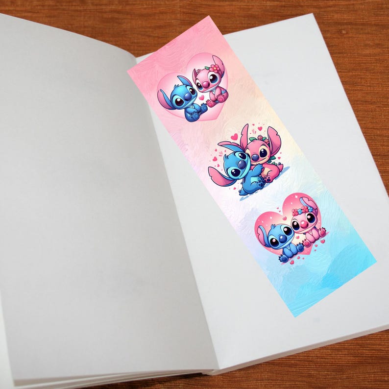 May include: A colorful bookmark featuring cartoon characters in heart-shaped designs. The bookmark has a gradient background of pink and blue. The characters are blue and pink, with large eyes and expressive faces. The bookmark is placed inside an open book.