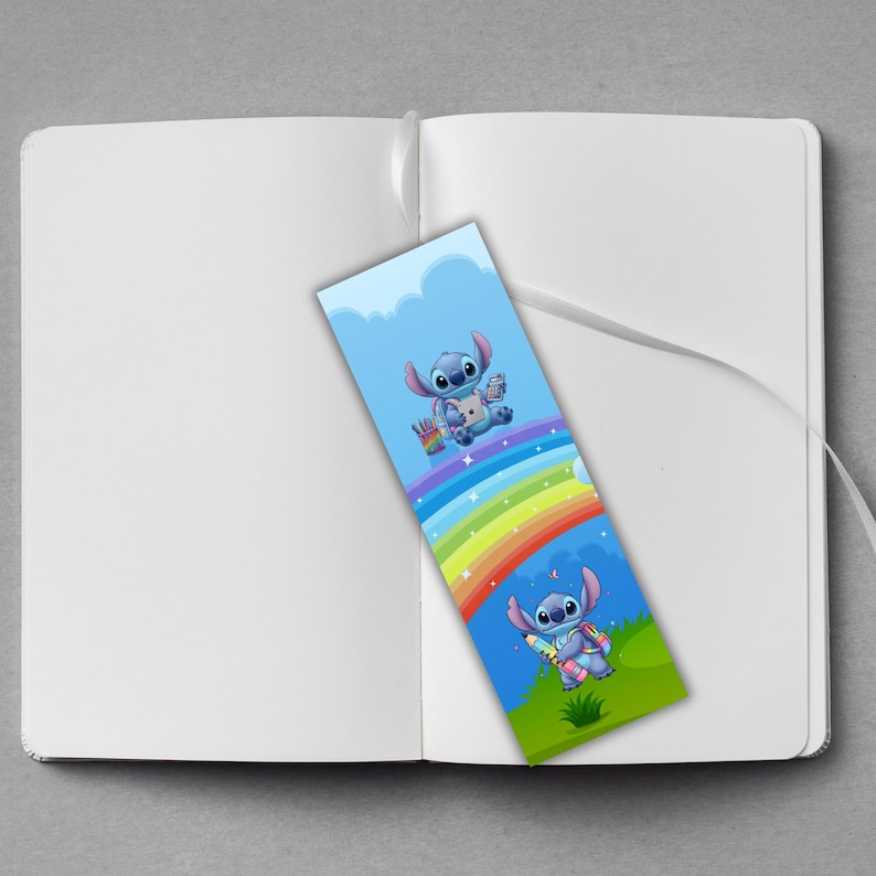 May include: A colorful bookmark featuring the character Stitch from Lilo & Stitch. The bookmark has a blue background with Stitch holding art supplies and a rainbow design. The bookmark is placed inside an open white notebook.