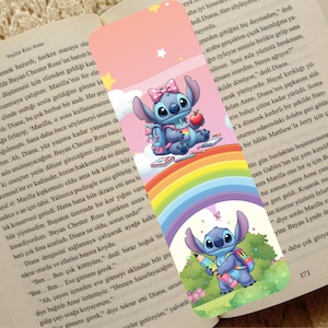May include: A colorful bookmark featuring the character Stitch from Lilo & Stitch. Stitch is depicted with a backpack, holding an apple and a drink, and sitting on a rainbow. The bookmark is set against a background of a book.