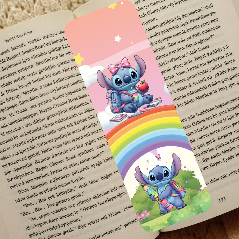 May include: A colorful bookmark featuring the character Stitch from Lilo & Stitch. Stitch is depicted with a backpack, holding an apple and a drink, and sitting on a rainbow. The bookmark is set against a background of a book.
