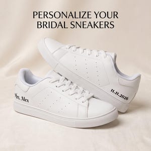 May include: A pair of white sneakers with white laces and soles. The text "PERSONALIZE YOUR BRIDAL SNEAKERS" appears at the top. One sneaker features the black text "Mrs. Alex" and the other features the black date "11.11.2026" on the side.