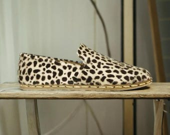 Può includere: Un paio di scarpe slip-on con stampa leopardata e suola in pelle marrone.