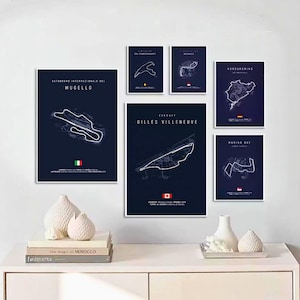 Puede incluir: Una colección de seis mapas de circuitos de carreras enmarcados en una pared blanca. Los mapas presentan dibujos lineales blancos de las pistas sobre un fondo azul oscuro. Cada mapa incluye el nombre de la pista y una bandera nacional. Jarrones blancos decorativos y libros en primer plano.