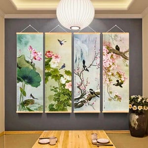 May include: Four vertical wall art panels with floral and bird illustrations. The panels feature a lotus flower, peonies, a snowy branch, and cherry blossoms. Each panel has a wooden rod at the top and bottom for hanging.