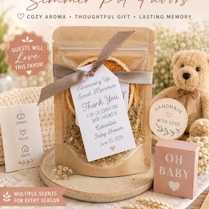 May include: A kraft paper pouch containing dried orange slices and botanical ingredients, tied with a brown ribbon and a white tag reading Simmering Up Sweet Memories Thank You FOR CELEBRATING BABY HADWICK Gabrielle's Baby Shower June 20, 2026.