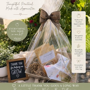 May include: A teacher gift basket kit in a clear cellophane bag with a brown ribbon bow. The kit includes a gift box, crinkle paper, a glass simmer pot, three simmer kits, a tea towel, and a small wooden sign that reads Thank you for helping me grow.