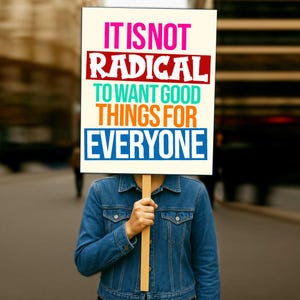 Puede incluir: Una persona sostiene un cartel con el texto "IT IS NOT RADICAL TO WANT GOOD THINGS FOR EVERYONE" en varios colores. La persona lleva una chaqueta vaquera. El fondo está borroso, lo que sugiere un entorno al aire libre.