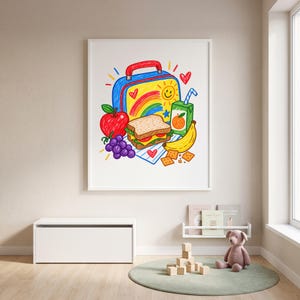 May include: A framed wall art print featuring a colourful crayon-style drawing of a lunchbox, a sandwich, a red apple, a bunch of purple grapes, a yellow banana, a juice box with a straw, and several square crackers on a white background.