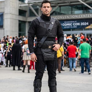 Mandalorian dark gray flight suit cosplay featuring a 5-piece bounty hunter outfit with matching vest and tactical design inspired by Star Wars armor builds. This Mandalorian costume is perfect for cosplay conventions, Comic Con, Halloween events, fan expos, and photography. The flight suit includes a comfortable fit, detailed stitching, and screen-inspired styling ideal for Din Djarin cosplay, bounty hunter costumes, Mandalorian outfits, and custom sci-fi costume builds.