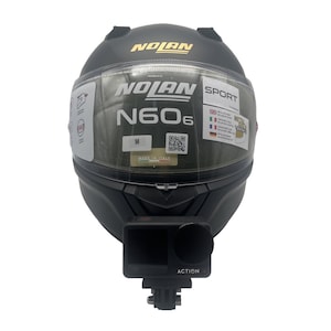Puede incluir: Un casco de moto integral Nolan N60-6 en negro mate con visera transparente, logotipos de Nolan y Sport, etiqueta de talla M, código QR y etiqueta Made in Italy. Una cámara DJI Action 4 negra está montada en la zona de la barbilla.