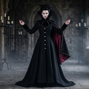 May include: A long black coat with silver buttons and a high collar. The coat has a red lining and is worn with a black cape. The person is standing in a stone hallway with candles.