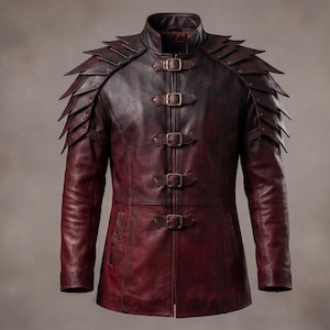 Puede incluir: Una chaqueta de cuero rojo oscuro con cuello alto, mangas largas y cuatro cierres de hebilla frontales con herrajes en tono latón. Los hombros están adornados con escamas de cuero superpuestas y puntiagudas que bajan por los brazos.