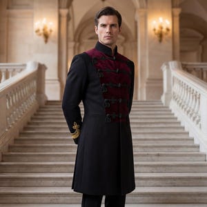 May include: A black coat with a burgundy velvet panel on the chest and gold embroidered accents on the sleeves. The coat has a high collar and decorative buttons. The person is standing in front of a grand staircase.