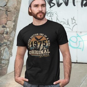 Puede incluir: Camiseta negra con un gr&aacute;fico circular que presenta el a&ntilde;o "1975", monta&ntilde;as y las palabras "Original Vintage". El dise&ntilde;o incluye un &aacute;guila y el texto "Limited Edition - One of a Kind".