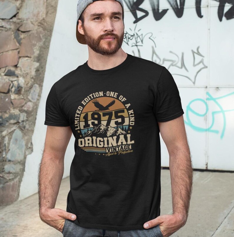 Puede incluir: Camiseta negra con un gr&aacute;fico circular que presenta el a&ntilde;o "1975", monta&ntilde;as y las palabras "Original Vintage". El dise&ntilde;o incluye un &aacute;guila y el texto "Limited Edition - One of a Kind".